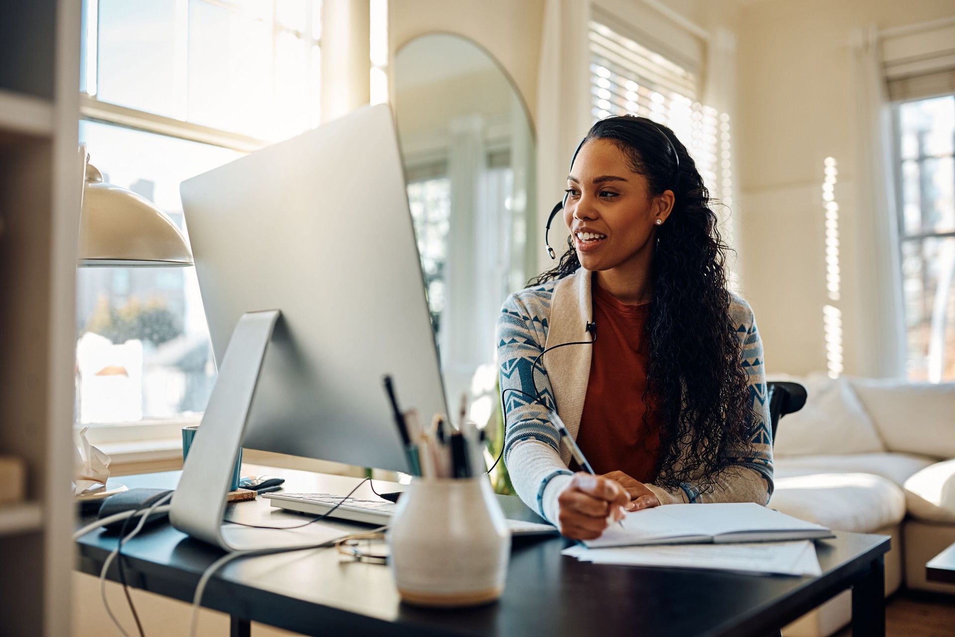 Happy African American female student having video call while e-learning at home.